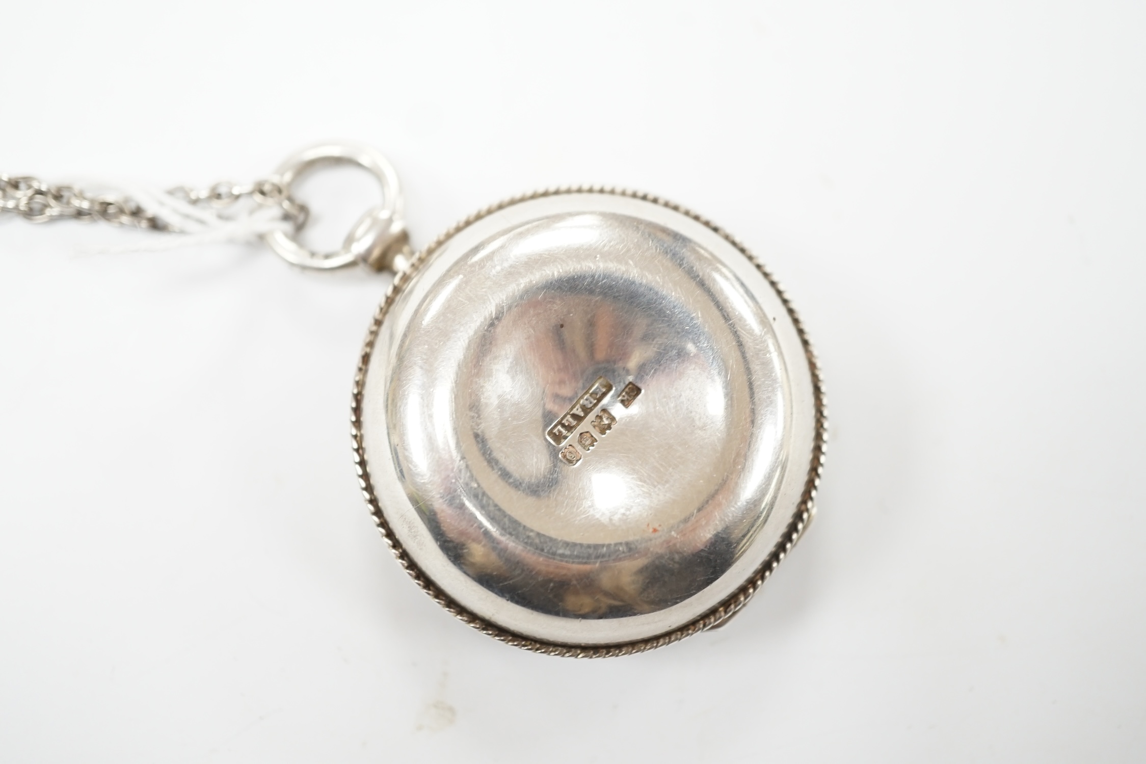 An Edwardian silver circular pyx by Carl Krall, the cover engraved with a bird with new born chicks, London, 1909, diameter 43mm, together with a white metal chain. Good condition